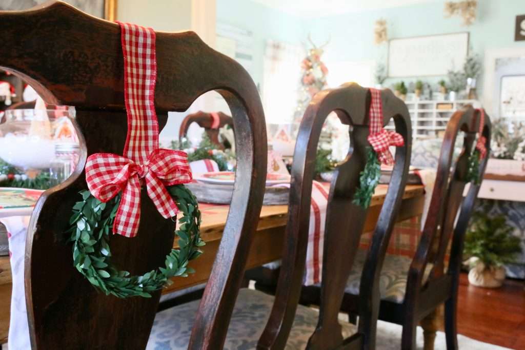 mini wreaths tied to the back of dining chairs