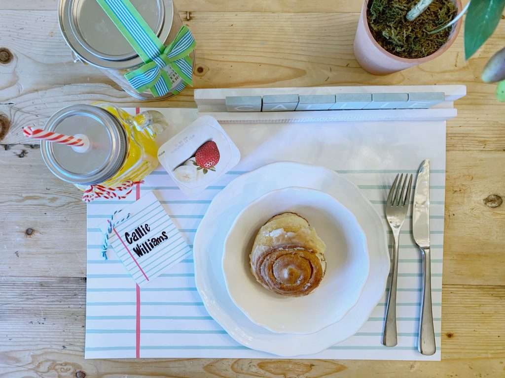 back to school pacesetting Back to School themed breakfast with cinnamon roll, yogurt and juice on a notebook paper placemat.