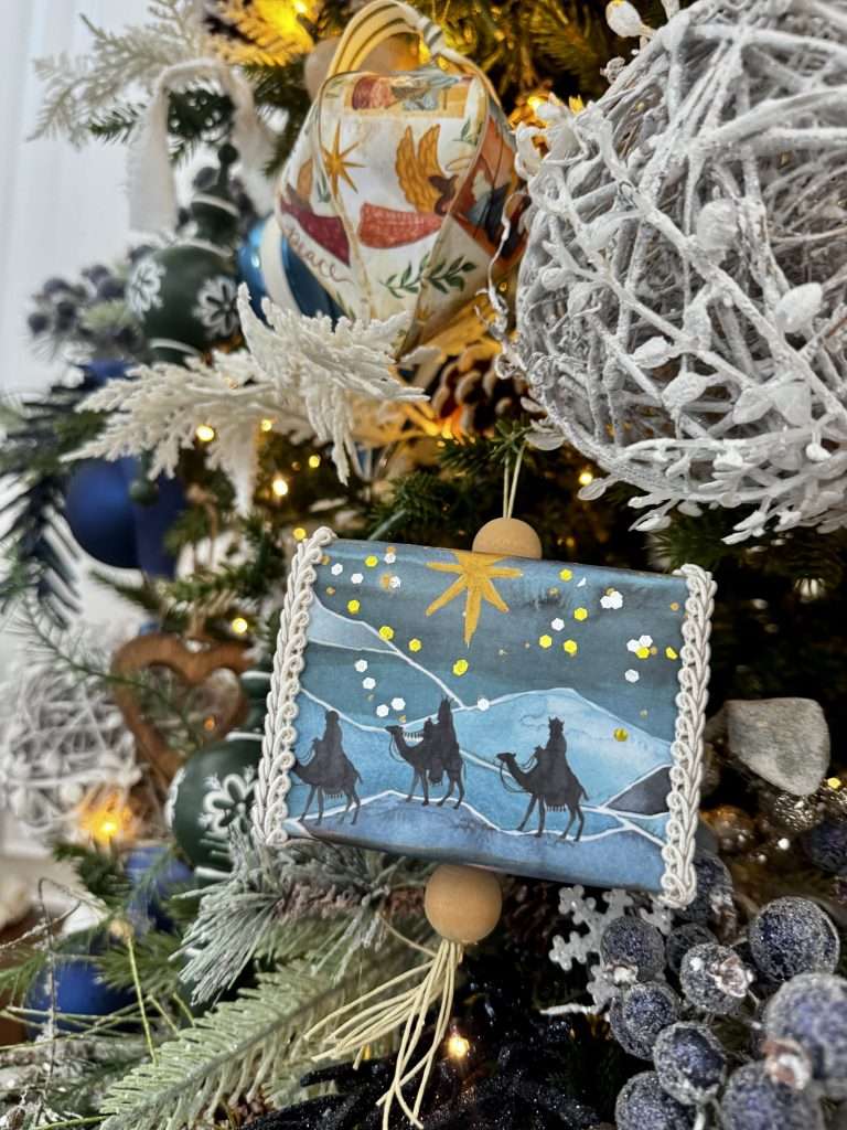 Decoupage paper mâché Christmas ornaments with vintage patterns and neutral cottage-style decor.