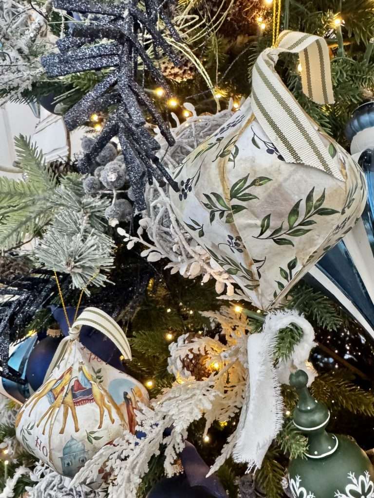 Decoupage paper mâché Christmas ornaments with vintage patterns and neutral cottage-style decor.